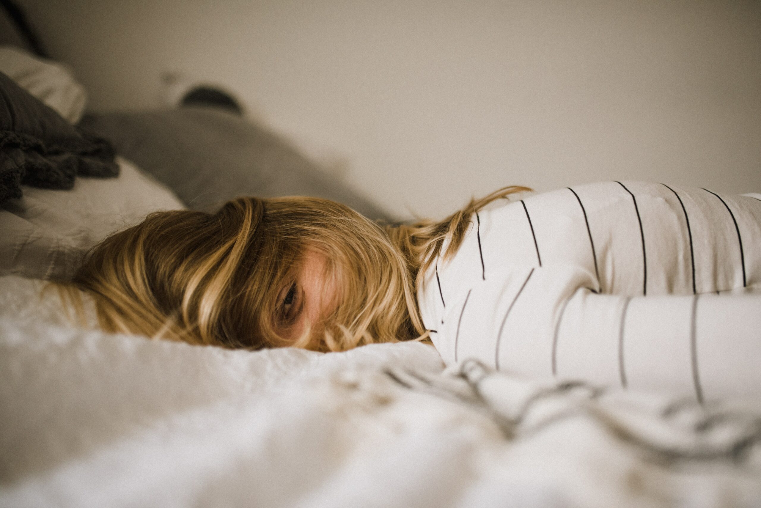 Video: Krystal Jakosky's 5 Ways to Beat Burnout a blonde woman laying face down on a white sheet